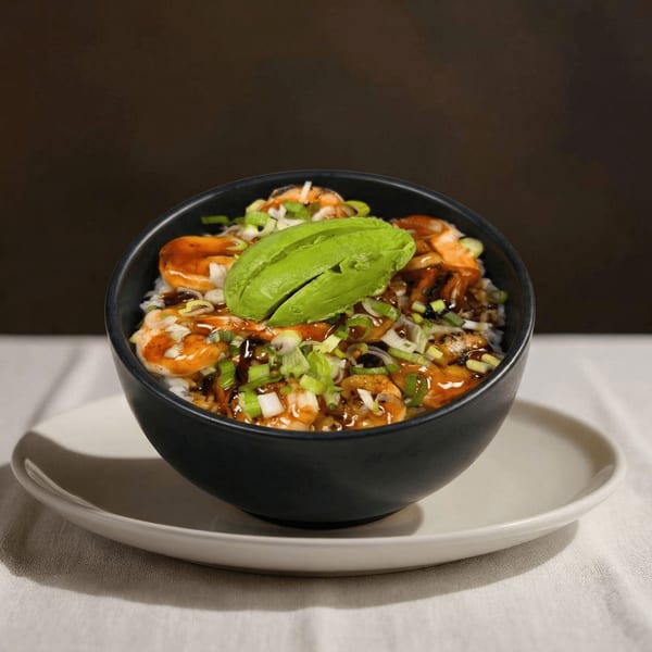 A black bowl of shrimp and rice, topped with avocado slices and green onions.